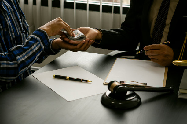 一个商人在法官的锤子锤前贿赂律师。欺诈洗钱的概念图片下载