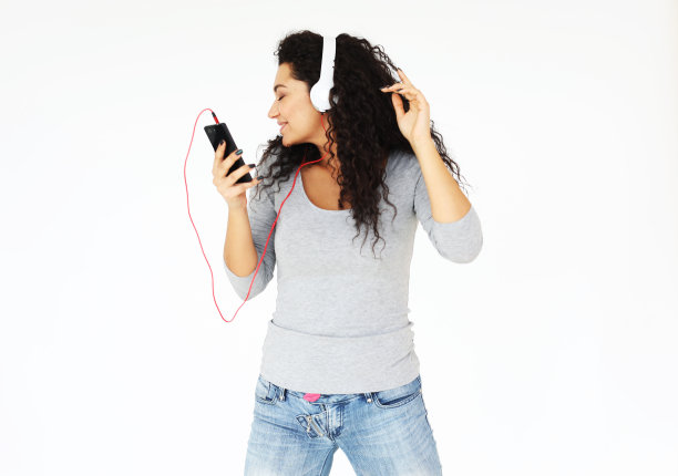 生活方式和人们的观念:年轻女性在家，戴着耳机听音乐图片下载