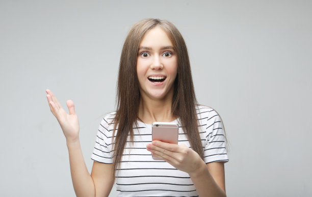 高兴兴奋的女高兴地收到短信，盯着手机图片下载