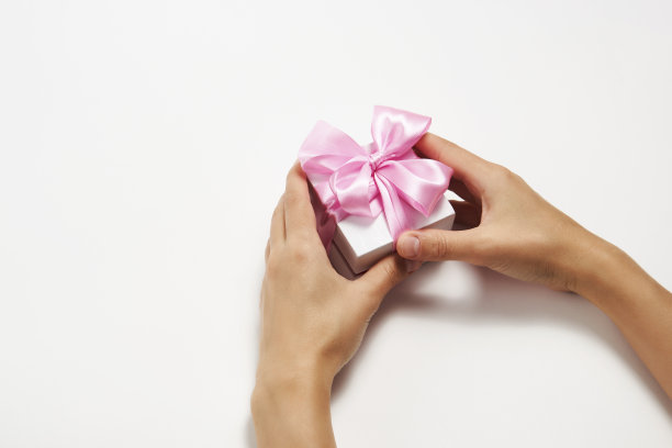 女性手握白色背景丝带小礼品盒图片下载