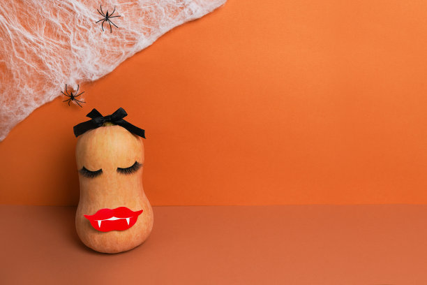 万圣节南瓜化妆和蜘蛛网。万圣节假期概念背景图片下载