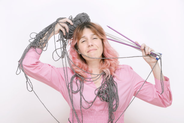 紧张的女人用羊毛和针织针图片下载