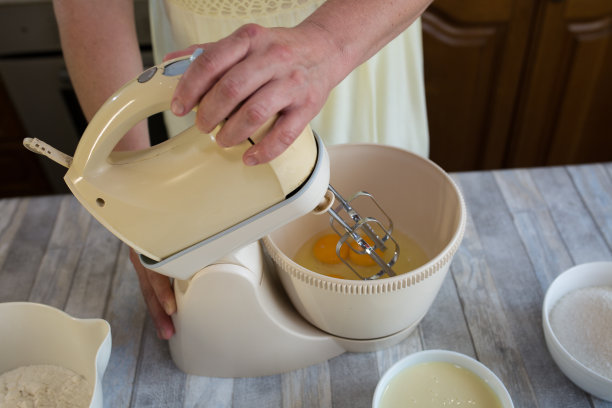 一步步制作酸奶油馅饼面团的过程。搅拌器把鸡蛋打在面团碗里。烘焙的概念。图片下载
