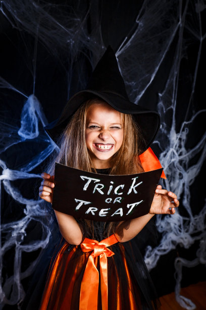小女孩穿着万圣节服装，不给糖就捣蛋。万圣节装饰图片下载