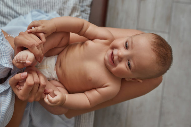 年幼的孩子喜欢赤身地坐在母亲裸露的膝盖上图片下载