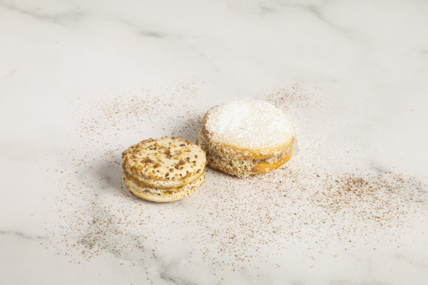 用糖装饰的Alfajores在一个有质感的桌子上，甜的食物在工作室的细节，美味的甜点图片下载