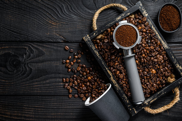 咖啡粉在Portafilter为浓缩咖啡在木制托盘与咖啡豆。黑色木制背景。前视图。本空间图片下载