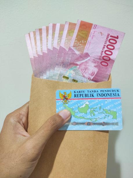 手握印尼盾钱在棕色信封和印尼盾电子身份证或KTP -股票照片。图片下载