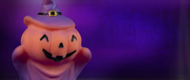 万圣节南瓜女巫娃娃紫色背景。图片下载