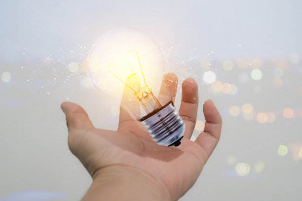 商人手中拿着发光的灯泡招牌图片下载