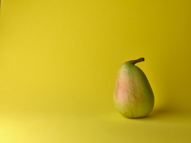 黄色背景上的梨。静物配梨子图片下载