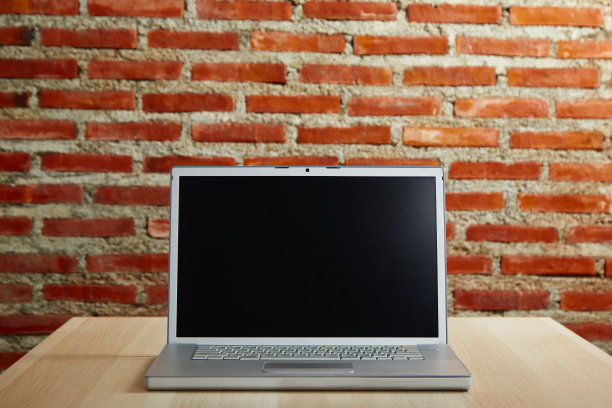 笔记本电脑的黑屏桌上工作，从家里图片下载