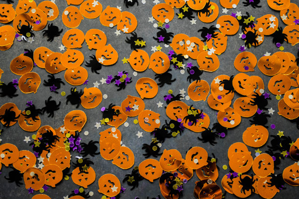 万圣节的背景:橙色南瓜、黑色蜘蛛和星星形状的五彩纸屑。本空间图片下载