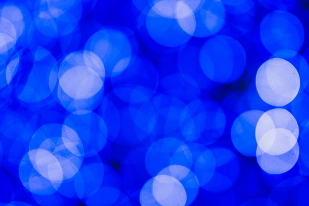 蓝色辉光散景灯和黑色背景的辉光图片下载