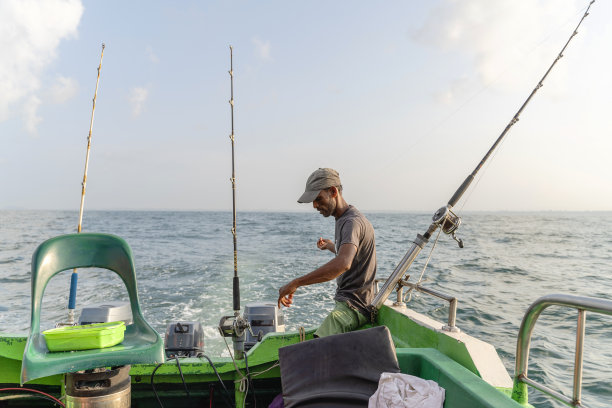 渔民设置钓竿准备在海洋上的一艘船的深海钓鱼运动。图片下载
