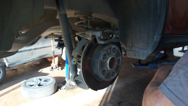 近男技师技师油手在安装新车制动钢转子盘。图片下载