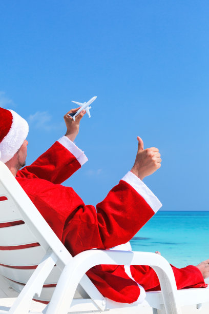 圣诞老人在太阳床上放松，圣诞贺卡图片下载