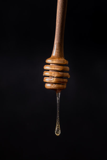 一滴蜂蜜滴在黑色背景上，孤立的，正面的画面图片下载