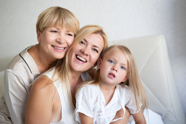 全家福:妈妈、女儿和外孙女坐在床上图片下载