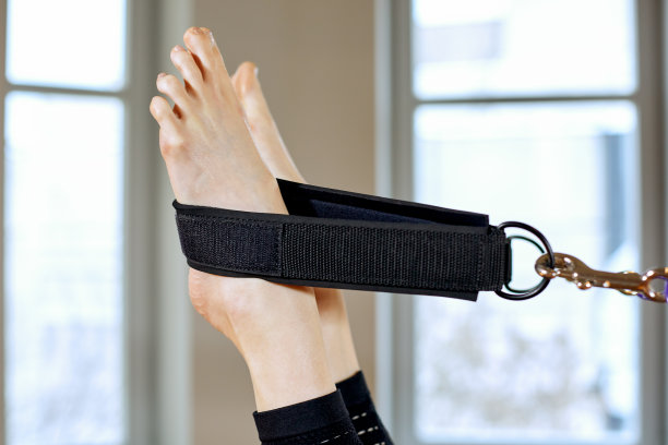 体操女人普拉提伸展运动在改革家床教练女孩。腿关闭图片下载