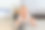可爱可爱的小男孩或女孩躺在地板上试图爬，穿着白色的衣服，看着相机，独自在室内玩，快乐的童年。图片下载