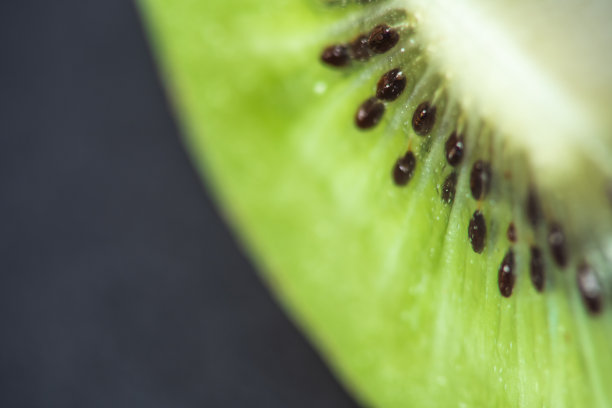 宏观水果:一个成熟猕猴桃的极端特写，黑色背景，水平格式图片下载