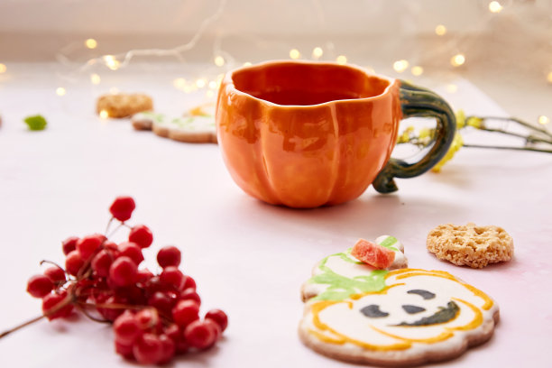 万圣节创意:南瓜杯和节日南瓜形状的甜饼干。大气美学的秋季意境还是恶作剧或款待的概念。荚蒾和蜜饯水果装饰品图片下载