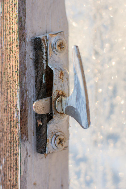 开着的木门上的古老而不现代的门闩。锁上了漆，门闩在窗户上。垂直照片，软，选择性聚焦。图片下载