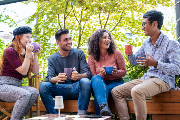 一群朋友在开放的自助餐厅喝着咖啡和卡布奇诺休息，多元文化的人在咖啡吧喝着浓咖啡，学生朋友在一起放松图片下载