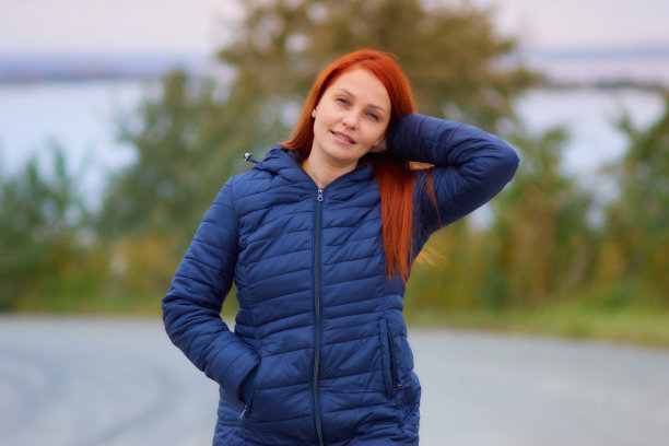 一个生活风格的女人的肖像与红色的头发在秋天的背景下五颜六色的树叶图片下载