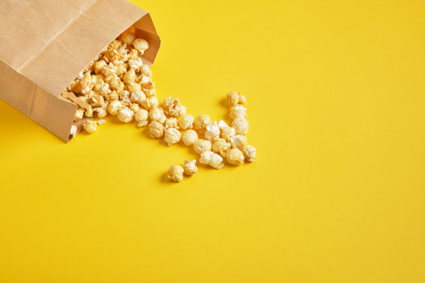 焦糖爆米花，纸袋，黄色背景。本空间图片下载