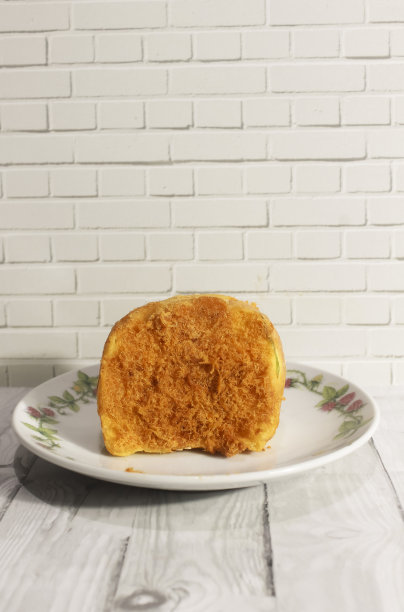 木桌上的白盘子上放着碎面包卷图片下载