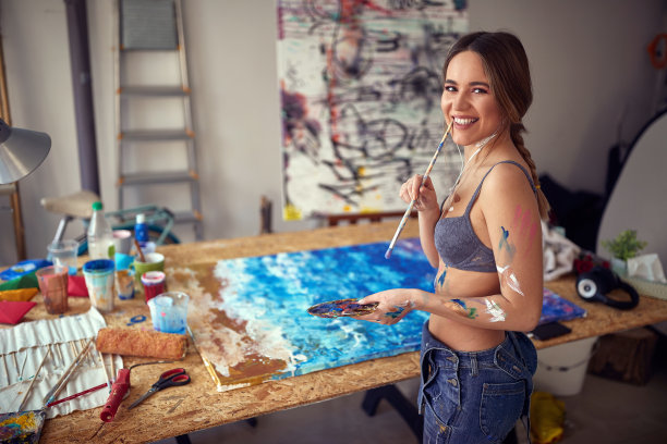 微笑性感和有吸引力的女性艺术家在她的画室里摆姿势拍照。艺术、绘画、工作室图片下载