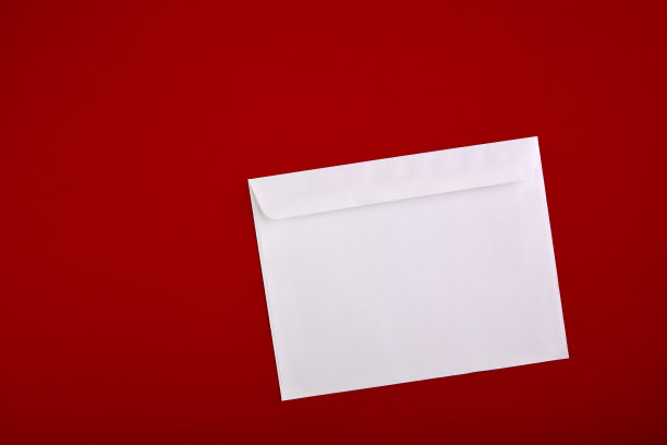 红色背景上的空白信封照片。品牌标识模板。信封模型。白纸孤立在红纸上。俯视图图片下载