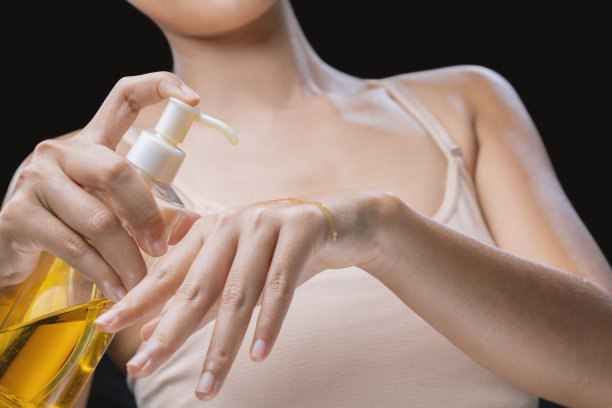 一位女士正在往皮肤上涂抹橄榄油。图片下载