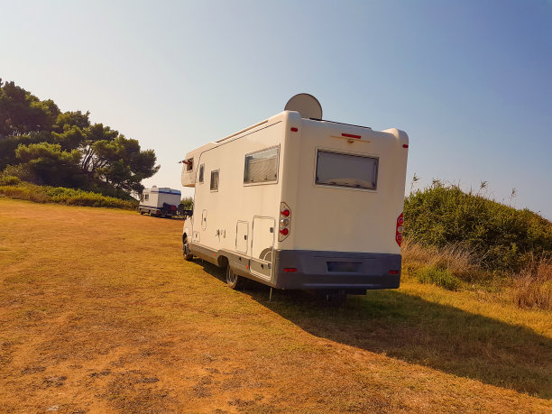 清晨，大篷车在秋色的松树旁上坡图片下载