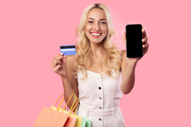 微笑的女人显示空白的智能手机屏幕和信用卡图片下载