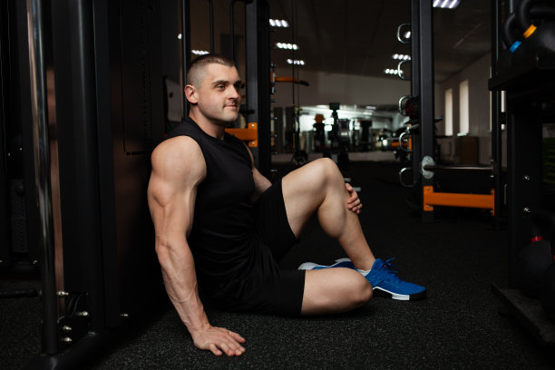 一个美丽的肌肉教练在健身房的肖像。个人课程，运动，减肥计划，团体课程。模拟器的广告。图片下载