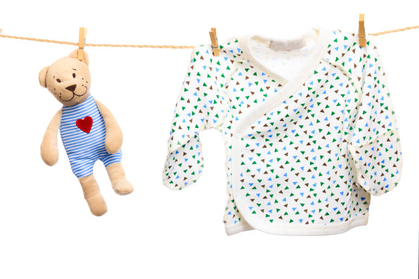 白色背景上晾衣绳上的婴儿衣服和泰迪熊-图片图片下载