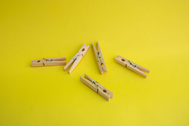 木制晾衣夹，在黄色背景上晾晒衣服图片下载