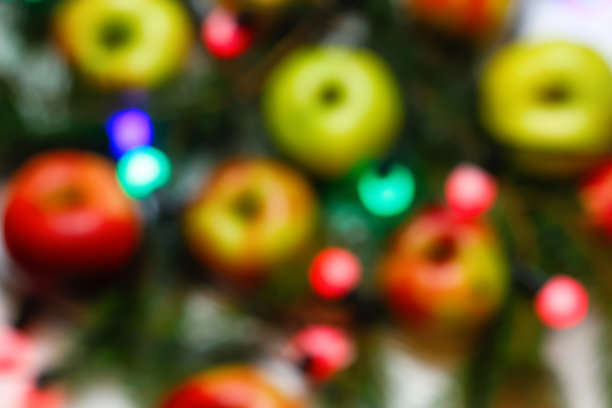 离焦圣诞抽象发光红，蓝，绿背景。节日的明亮模糊的背景。假期的设计。苹果果实。健康的饮食习惯。的焦点图片下载