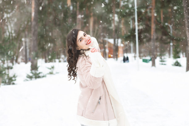 一位酷酷的女士在下雪的时候走在森林里图片下载