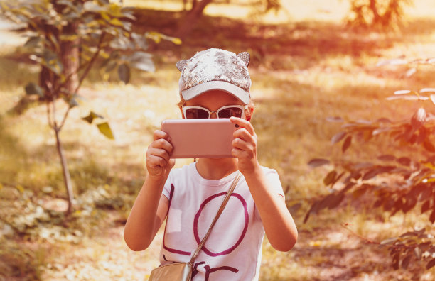 可爱的小女孩与长辫子在棒球帽户外阳光的日子青年文化生活方式真实的照片图片下载