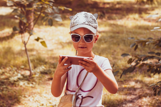 可爱的小女孩与长辫子在棒球帽户外阳光的日子青年文化生活方式真实的照片图片下载