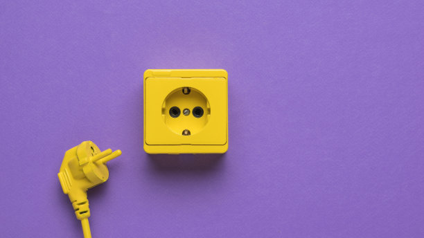 紫色背景上有一根黄色电源线和一个黄色插座。图片下载
