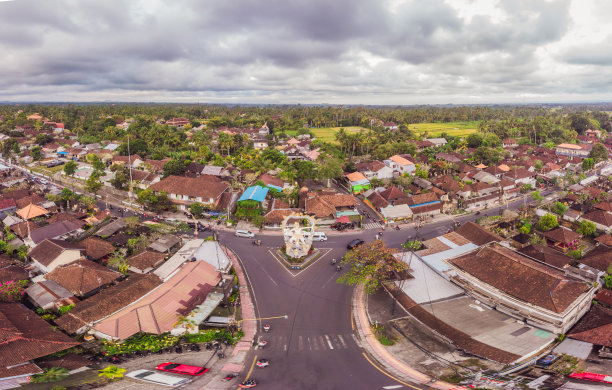 在巴厘岛的乌布，天空中热带树木之间的褐橙色瓦屋顶上有许多别墅。阳光照在他们身上。天线水平照片图片下载