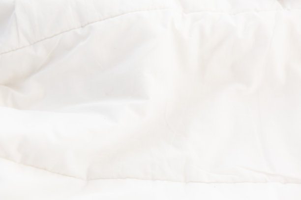 白色皱巴巴的毯子背景纹理，柔软的织物纹理背景墙纸。图片下载