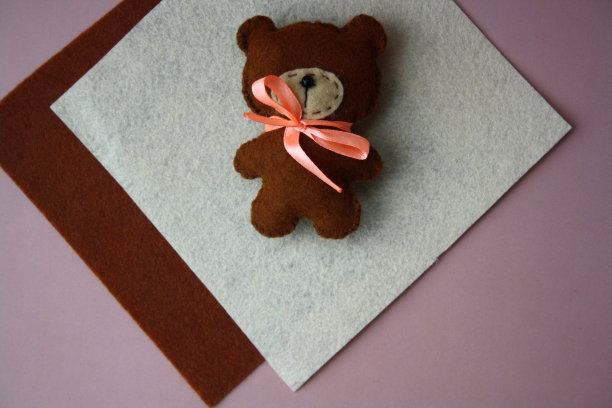 毛毡玩具用毛毡制成的儿童玩具布做的泰迪熊。有孩子的创造力。用自己的双手DIY项目。图片下载