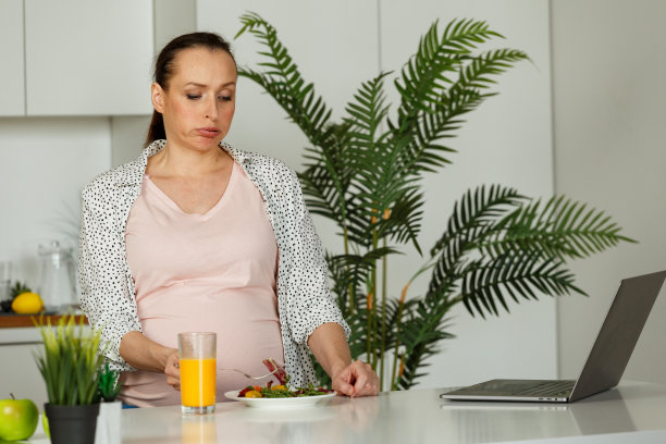 孕妇站在桌边吃饭没有胃口图片下载