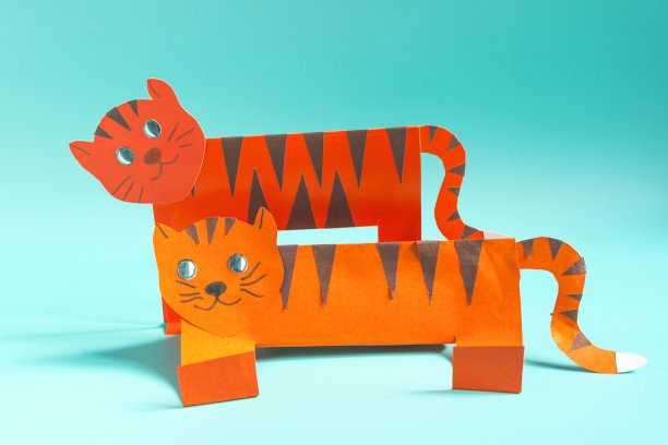 两只明亮的纸老虎在浅色背景上。2022年的象征是一只纸老虎的特写镜头图片下载